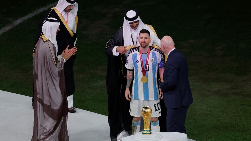 Honoured: Qatar's Sheikh Tamim bin Hamad al-Thani wraps a 'bisht' cloak around Lionel Messi 