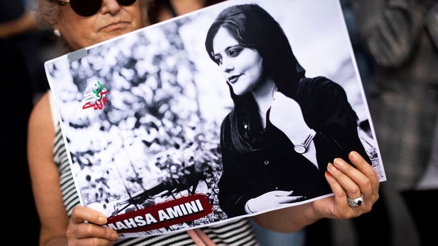 A protestor in Paris holds a portrait on October 29, 2022 of Iranian Mahsa Amini, who died in custody in September after her arrest by morality police in Tehran