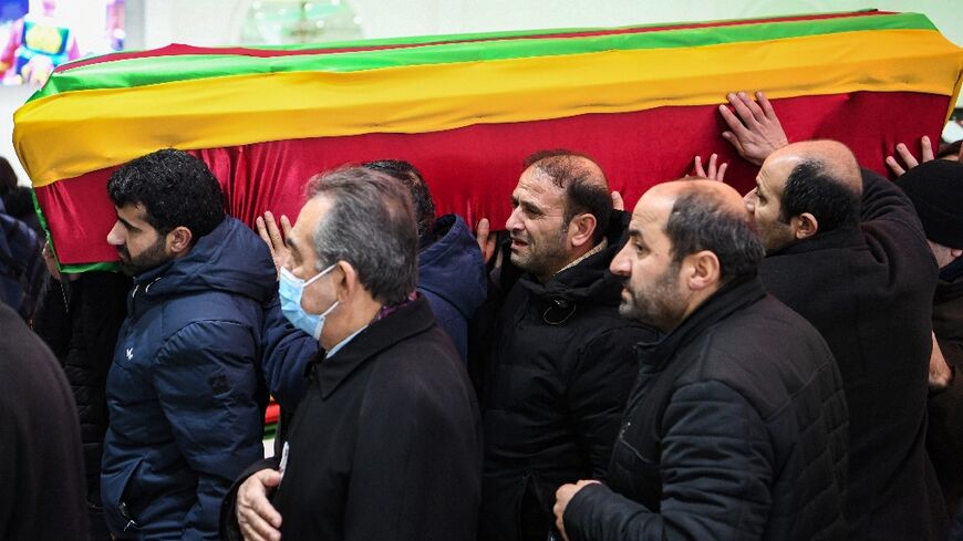 The coffins of the victims were draped in flags of Kurdish political causes