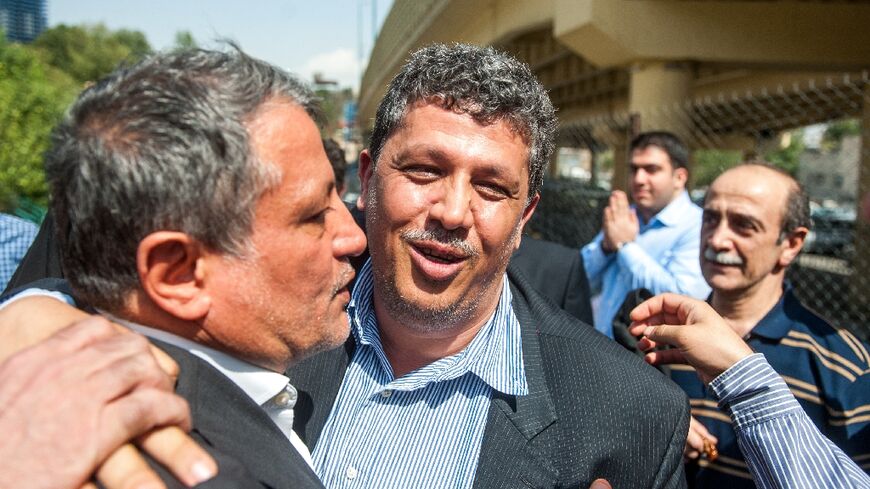 Former Iranian president Akbar Hashemi Rafsanjani's son Mehdi Hashemi (C), is hugged by his brother Mohsen (L) in August 2015 before entering Tehran's Evin prison to serve his sentence for fraud