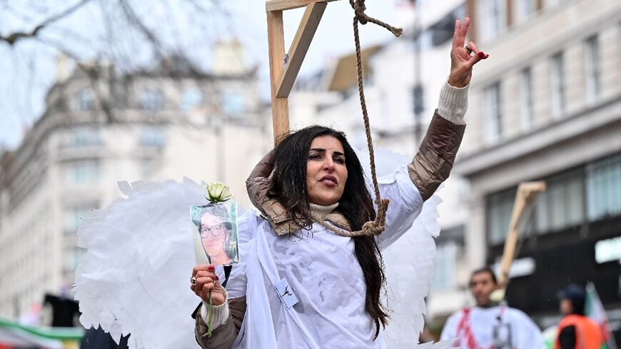 Protesters pose in mock gallows as they gather in central London on January 8, 2023 for a march against the Iranian regime