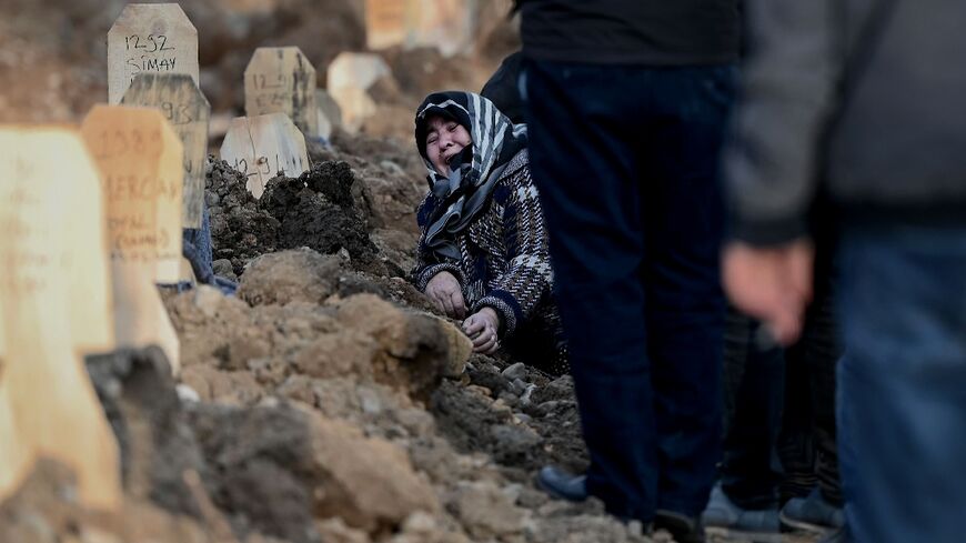 A woman mourns over the grave of her loved ones