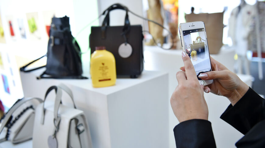 A visitor takes an images with a smartphone at the Designer Showcase during the Vogue Fashion Dubai Experience 2015 at The Dubai Mall on October 29, 2015 in Dubai, United Arab Emirates. (Photo by Jacopo Raule/Getty Images for Vogue and The Dubai Mall)