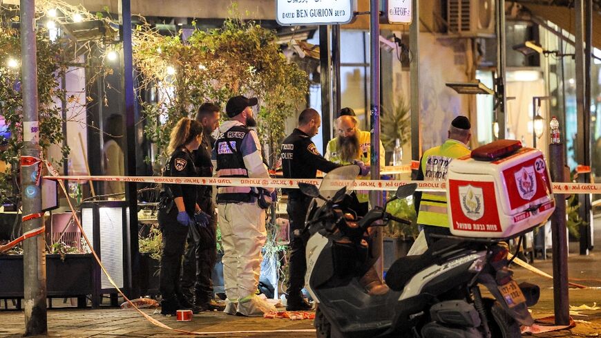 Israeli police, forensics experts, and paramedics at the scene of a shooting attack along Tel Aviv's Dizengoff Avenue 
