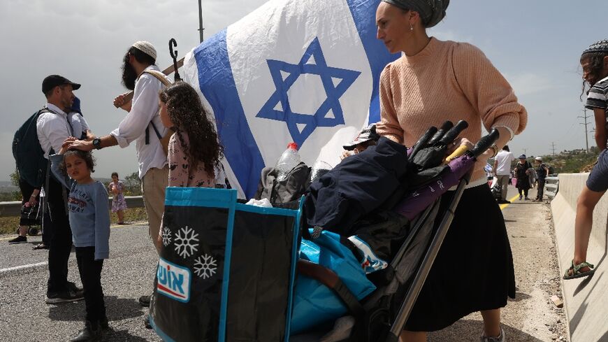 Israelis of all ages, including numerous armed men, walked to an outpost settlement built without approval from the state 