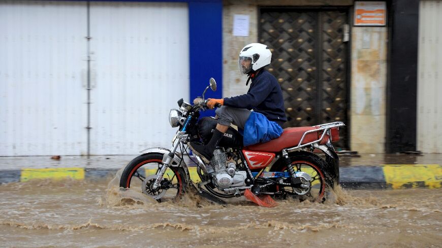 A man rides a motorcycles on a flooded street amid heavy rainfall in Yemen's capital Sanaa, which is controlled by Huthi rebels, on March 31, 2023