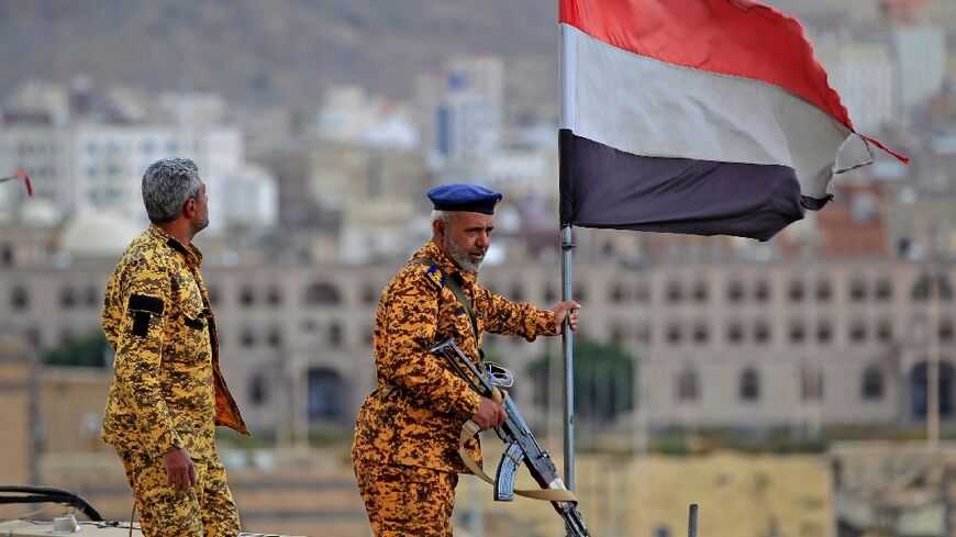 Fighters loyal to Yemen's Huthi rebels stand guard in the capital Sanaa during a rally on March 26, 2023