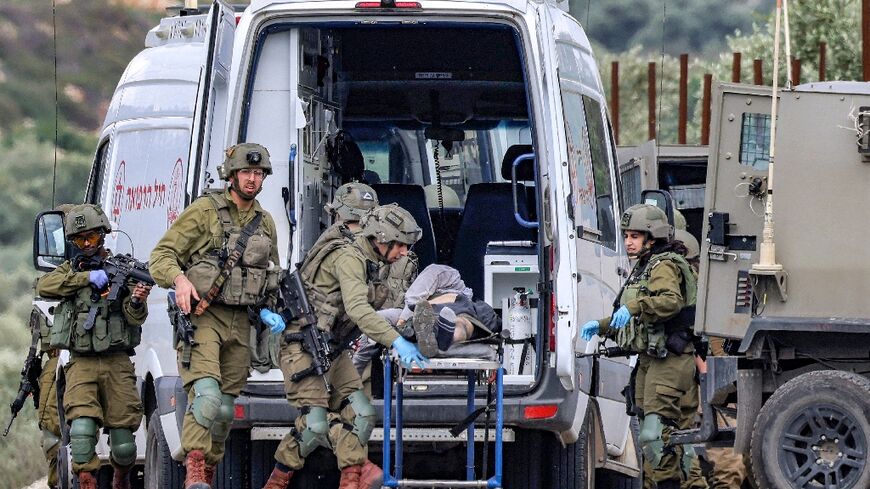 Israeli soldiers pass an ambulance with the body of a Palestinian militant killed during what the army called an exchange of fire near Elon Moreh settlement in the occupied West Bank