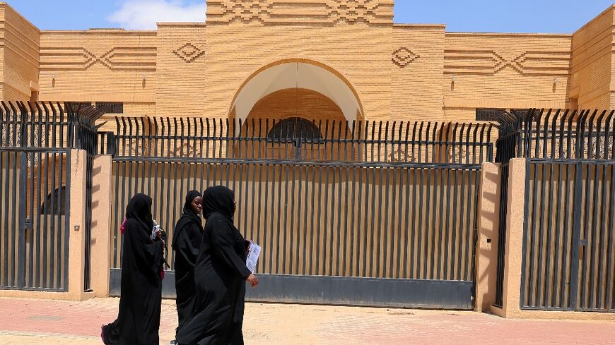Women walk past the closed Iranian embassy in the Saudi capital Riyadh