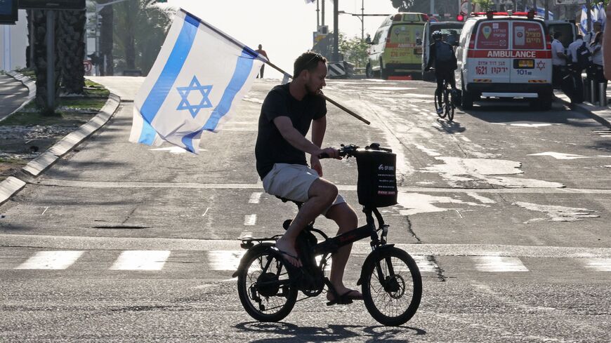 A protester rides his bicycle amid ongoing demonstrations against the government's judicial reform bill, in Tel Aviv on April 15, 2023. (Photo by JACK GUEZ / AFP) (Photo by JACK GUEZ/AFP via Getty Images)