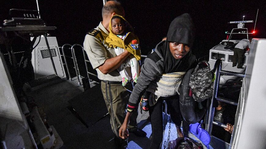 Migrants are rescued off their boat by the Tunisian National Guard about 50 nautical miles in the Mediterranean sea off the coast of Tunisia's central city of Sfax on October 4, 2022