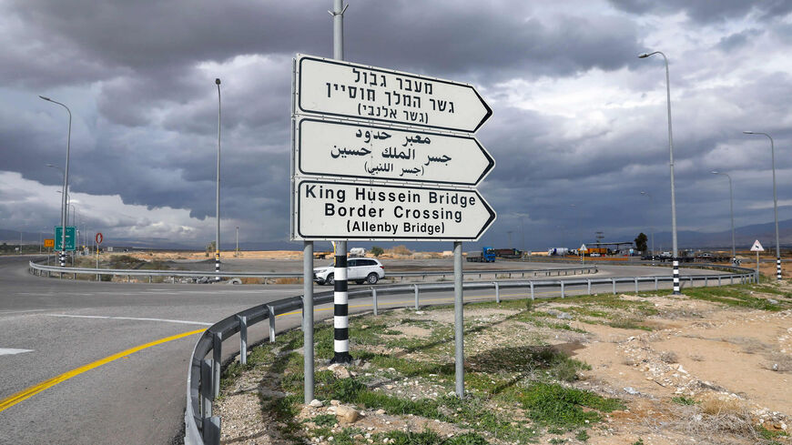 A car drives past a road signal indicating the Allenby (King Hussein) Bridge crossing point to Jordan (background), in the city of Jericho in the West Bank, on Jan. 28, 2021.