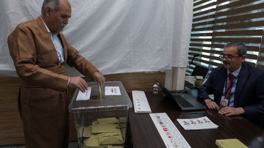 A Turkish citizen living in Arbil, the capital of the autonomous Kurdish region of northern Iraq, casts his ballot for the presidential and parliamentary elections, at the Turkish embassy