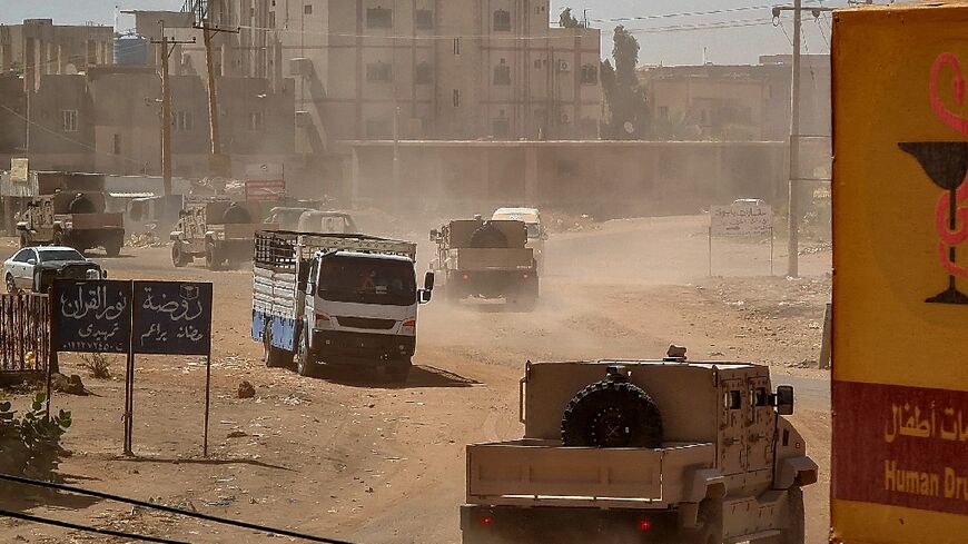 Sudanese army armoured vehicles drive in Khartoum, after paramalitaries seized the Central Reserve police headquarters in the city's south