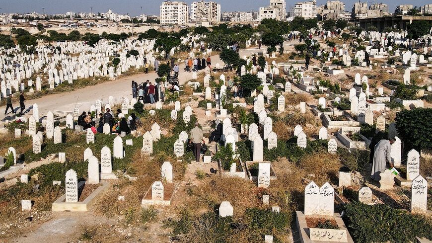 People visit the graves of loved ones at a cemetery on the first day of the Muslim feast of Eid al-Adha in Syria's rebel-held northwestern city of Idlib on June 28, 2023