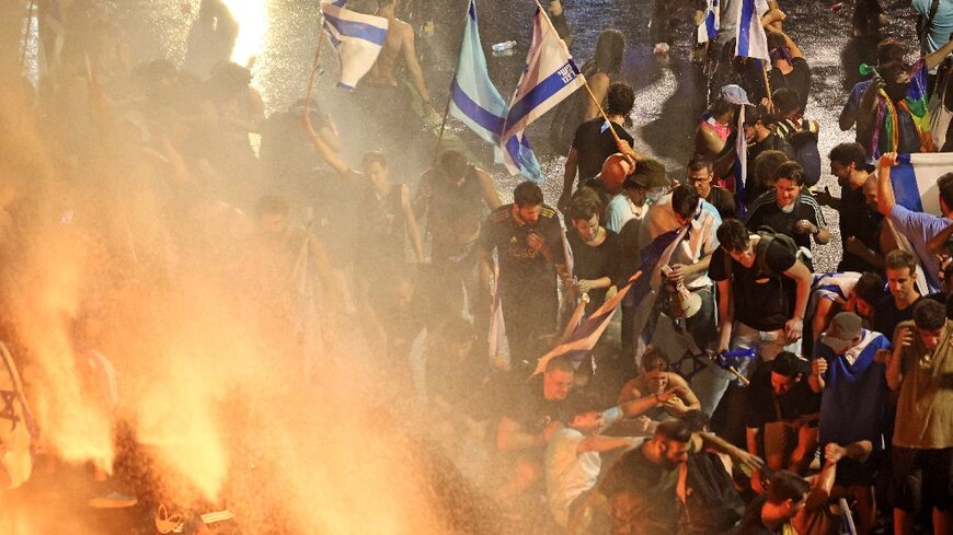 Demonstrators in Tel Aviv are sprayed with water cannon by Israeli riot police during a protest against the government's judicial overhaul plan, on July 24, 2023
