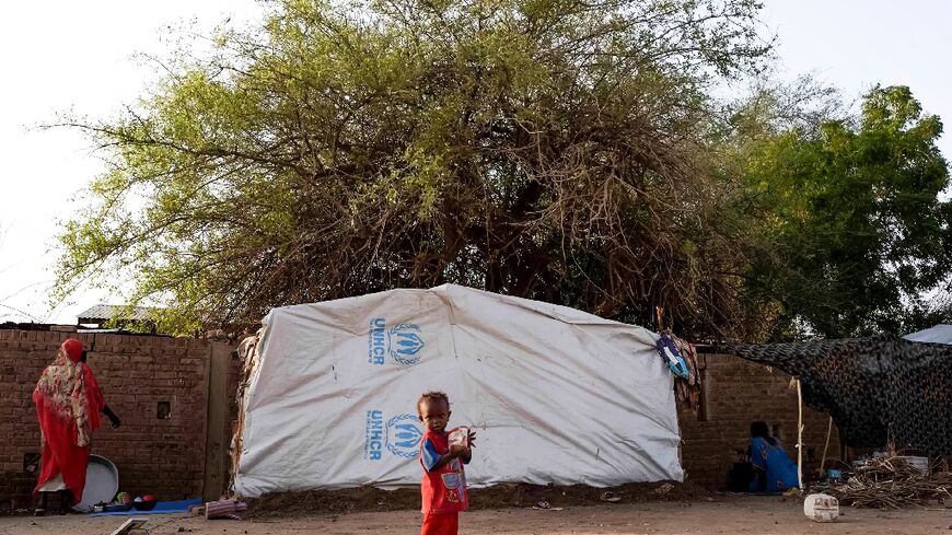 A displaced child outside a tent in al-Hasaheisa, where some of the more than 2.4 million people uprooted by Sudan's war have fled