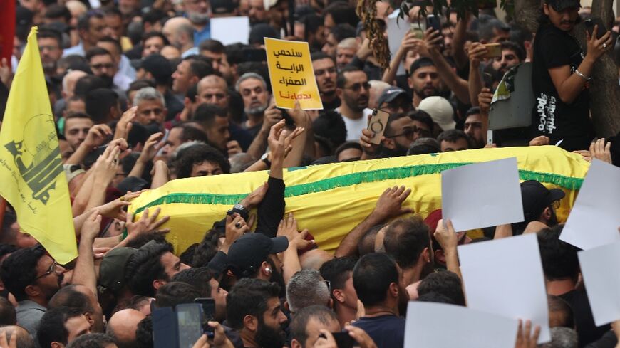 People carry the body of a fighter of the Lebanese Hezbollah movement during his funeral after he was killed in clashes
