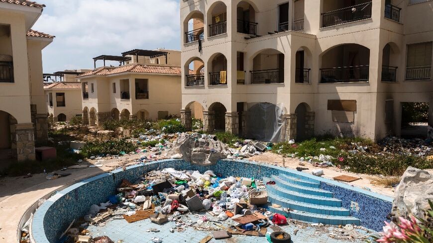 A swimming pool is filled with garbage at the Ayios Nikolaos apartment complex