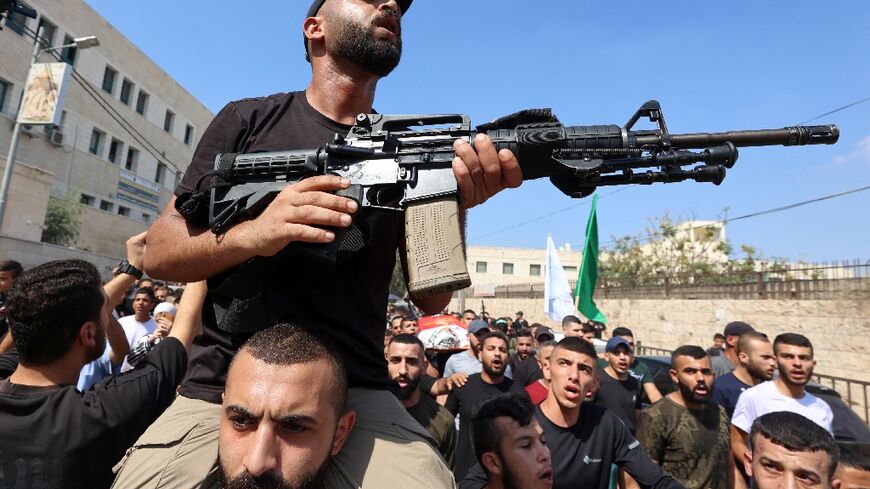 Gunmen take part in the funeral procession of three Palestinians killed in an Israeli raid on the Jenin camp for Palestinian refugees in the occupied West Bank