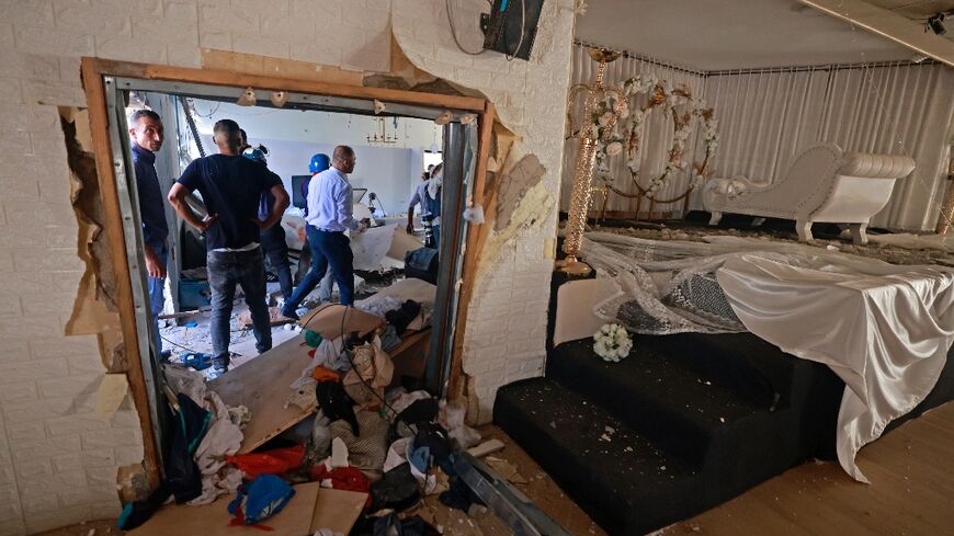 Palestinians inspect the damage following an Israel military raid in the occupied West Bank village of Al-Aqaba