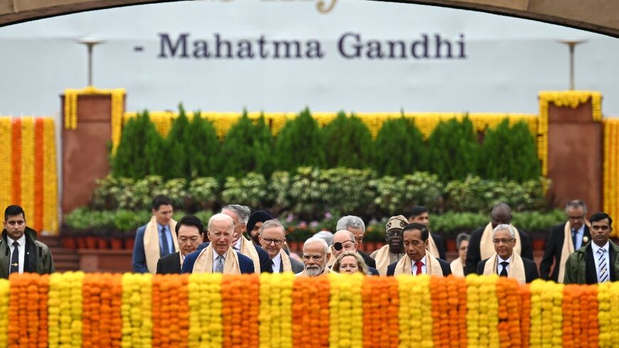 India's Prime Minister Narendra Modi (C) along with world leaders arrive to pay respect at the Mahatma Gandhi memorial in New Delhi