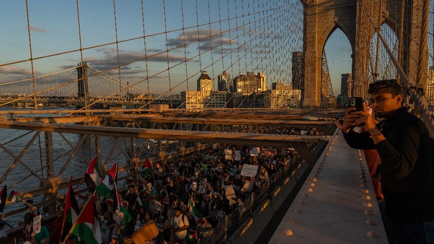 People cross the Brooklyn Bridge as they take part in a protest in support of the Palestinian people