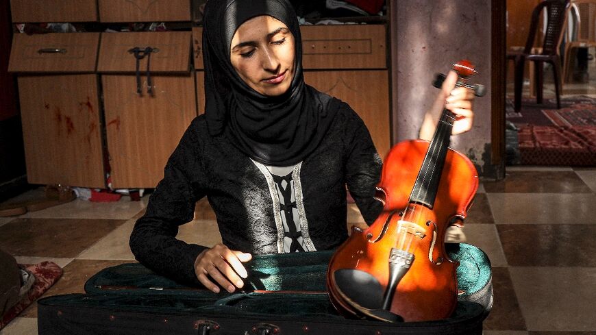 Gaza Strip English teacher Jawaher al-Aqraa says she plays her violin to "block out" the roar of Israeli fighter jets flying bombing runs over the besieged Palestinian territory