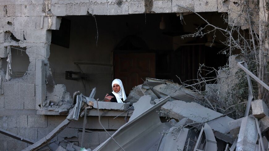 A woman looks out onto the rubble of a building destroyed in an Israeli bombardment in Rafah in the southern Gaza Strip on October 21, 2023