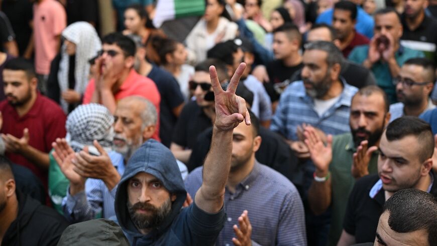 A Palestinian man flashes the victory sign during a demonstration in Ramallah in the occupied West Bank on October 18, 2023, protesting a strike on a Gaza hospital which killed hundreds a day earlier