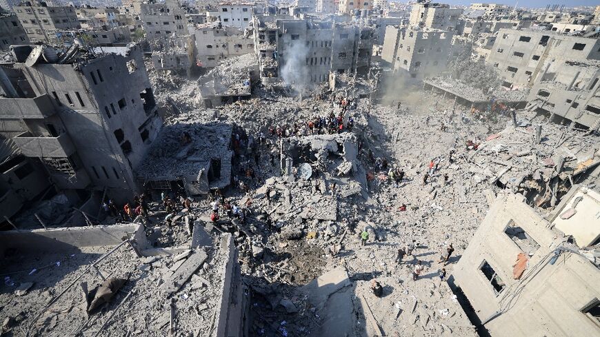 People search for survivors and bodies in the rubble of buildings destroyed in a strike on the Bureij refugee camp in the central Gaza Strip on November 2, 2023