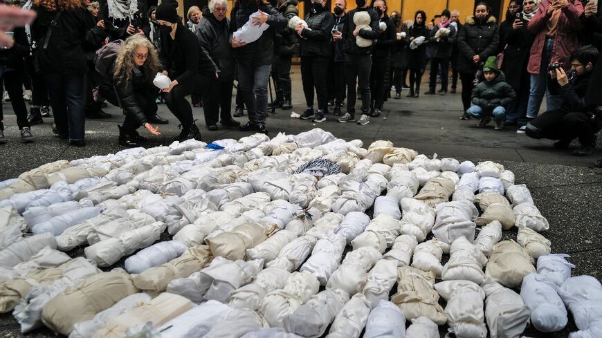 People gather and mourn in front of 500 baby dolls wrapped in a shroud, in remembrance of children killed in the Gaza Strip, in New York on December 28, 2023.