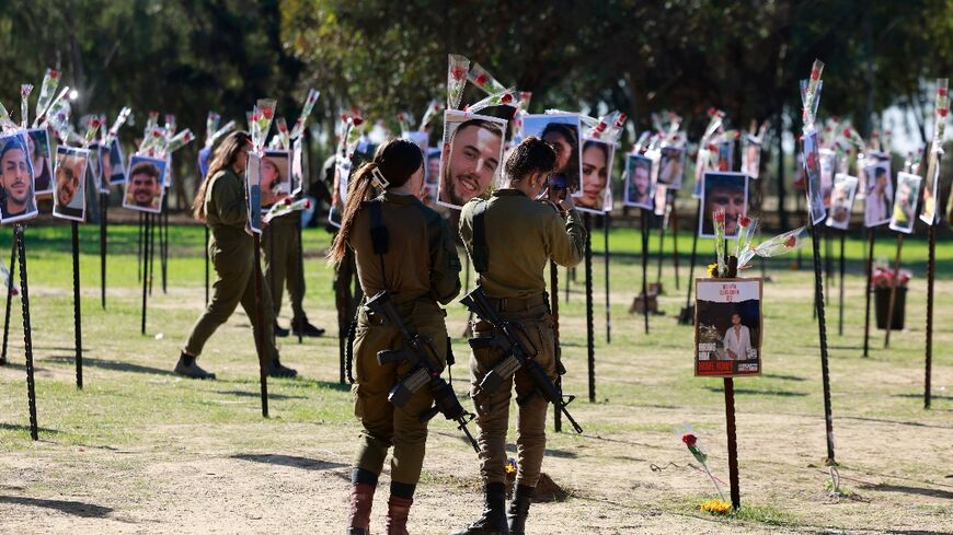 Israeli soldiers pay their respects to those killed or taken hostage by Hamas at the Supernova music festival