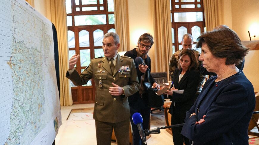 UNIFIL chief Aroldo Lazaro (L) shows a planning map of the Lebanon-Israel border area at a meeting with France's Foreign Minister Catherine Colonna