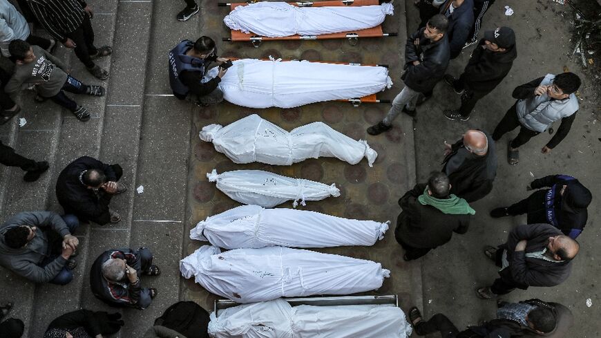 Mourners stand by shrouded bodies of relatives at Khan Yunis's Nasser hospital