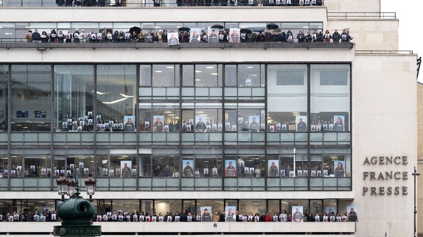 AFP journalists held up portraits of their colleagues in Gaza at the agency's Paris headquarters