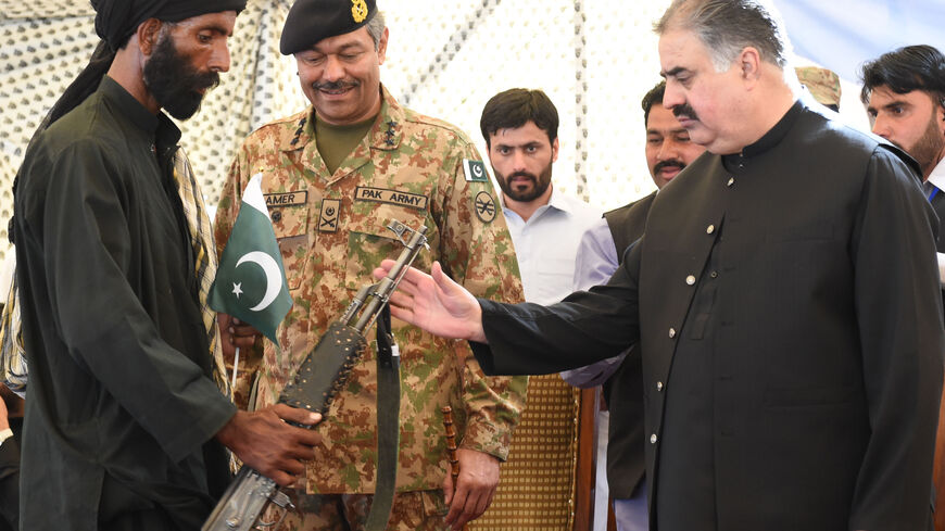 A Baloch militant (L) hands over his gun and surrenders to Baluchistan province Chief Minister Sardar Sanaullah Khan Zehri (R) in Quetta on April 21, 2017. Around 500 Baloch rebel militants on April 21 surrendered to Pakistan's government as Islamabad pursues its development agenda linked to the ambitious China Pakistan Economic Corridor (CPEC) in the southwest province. / AFP PHOTO / BANARAS KHAN (Photo credit should read BANARAS KHAN/AFP via Getty Images)