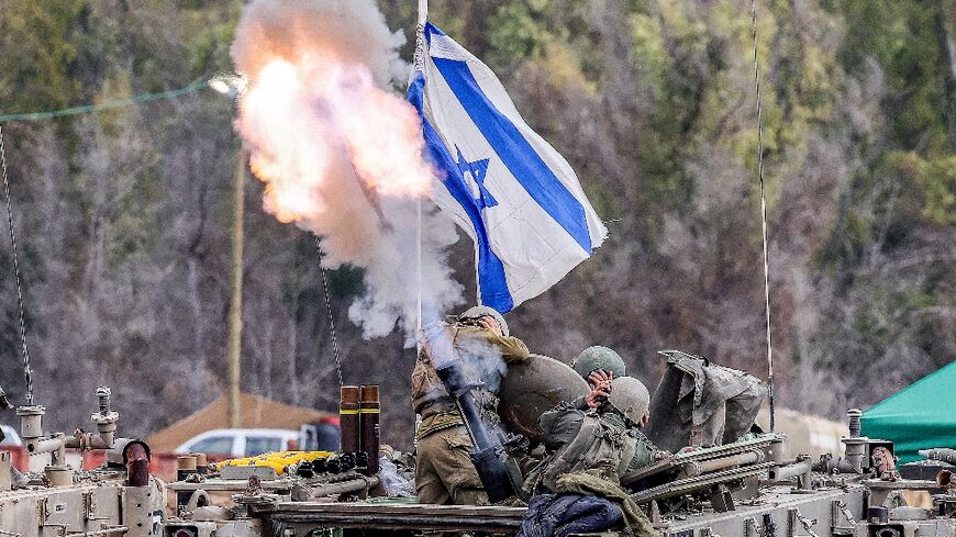 Israeli soldiers fire mortar rounds from an armoured vehicle at a position along in southern Israel on Wednesday