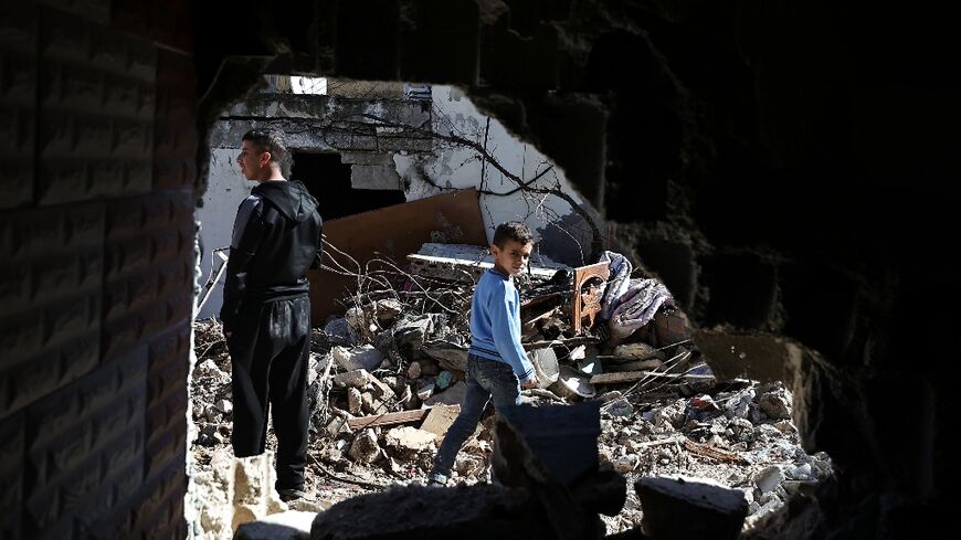 Palestinians inspect the damage in Nur Shams refugee camp as an Israeli raid on the Tulkarem area of the occupied West Bank enters a second day