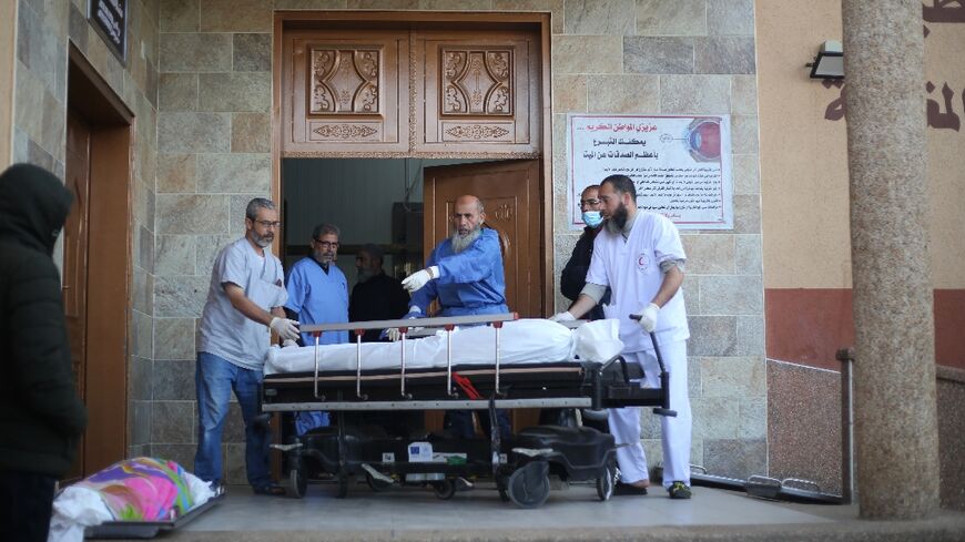 Doctors move a body ahead of prayers at Nasser hospital in Khan Yunis in December