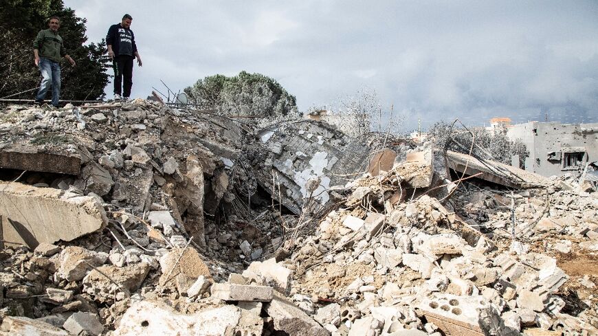 Lebanese men check the destruction following an Israeli air strike on the village of Sawwaneh