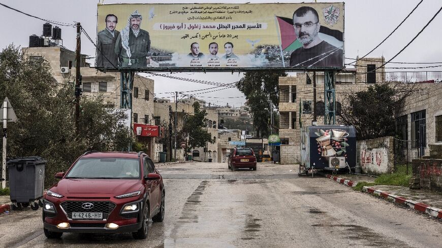 A poster depicting Palestinian prisoner Muhammad Zaghloul Hassan (R) and Palestinian leader Yasser Arafat is seen outside his family home