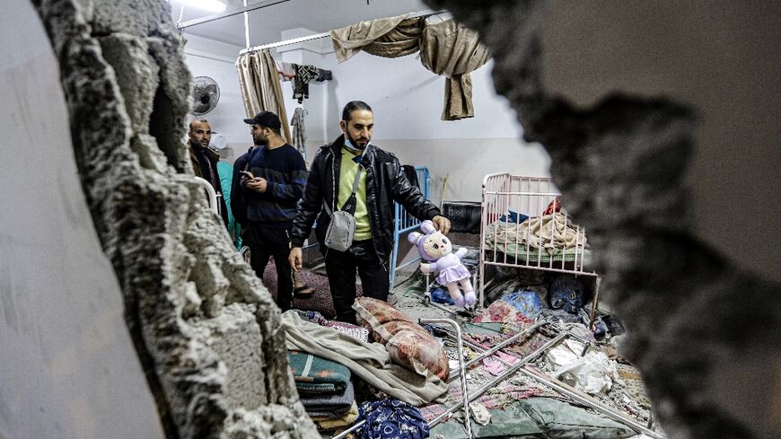 People inspect damage to a room following Israeli bombardment at Nasser hospital in Khan Yunis on December 17, 2023