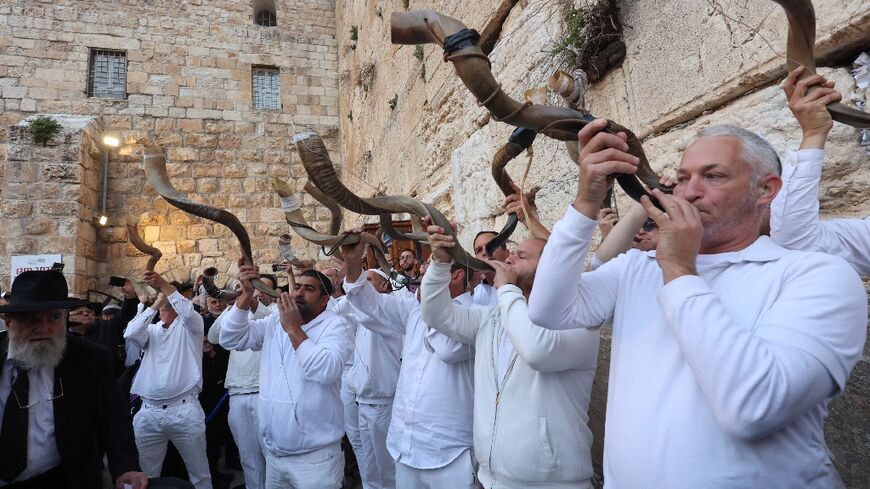 Israelis blows a shofar, a Jewish musical horn typically made of a ram's horn, during mass prayer calling for the release of Israeli hostages held in Gaza at Jerusalem's Western Wall 