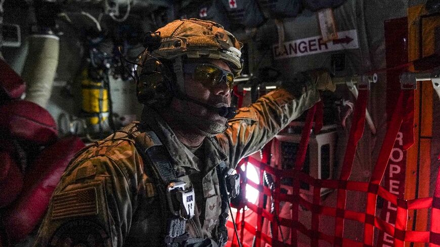 A member of the US Air Force 26th Expeditionary Rescue Squadron aboard an HC-130J aircraft prepares to airdrop humanitarian aid supplied by Jordan over the Gaza Strip