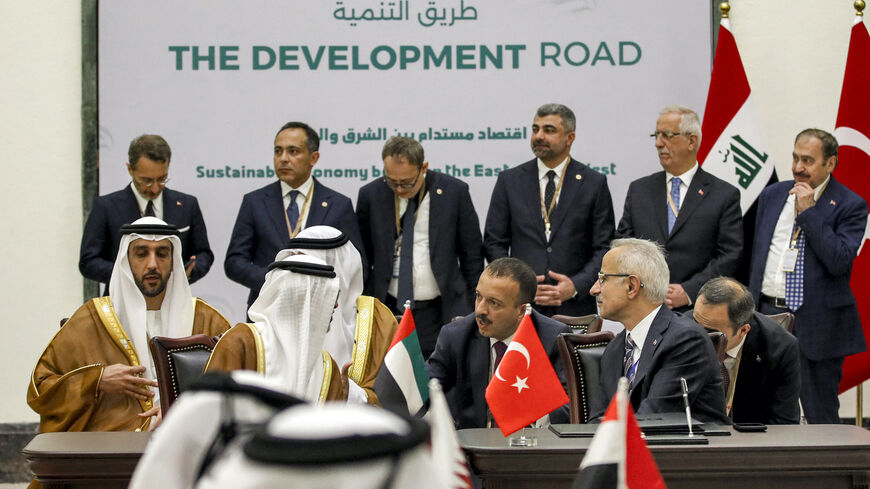 UAE's Energy Minister Suhail Mohamed al-Mazrouei (L) and Turkey's Transport Minister Abdulkadir Uraloglu (R) speak together during the signing of the "Development Road" framework agreement on security, economy, and development in Baghdad on April 22, 2024. 