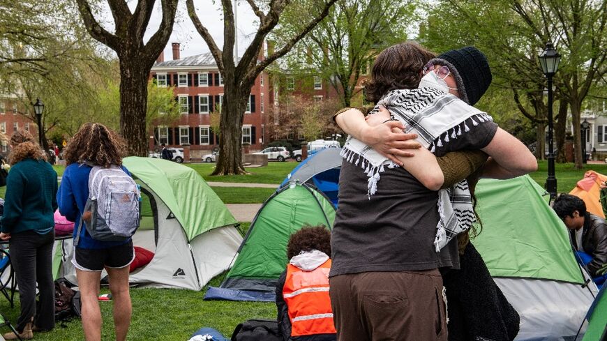 Pro-Palestinian students embrace each other as they take down their encampment after reaching a deal with Brown University in Providence, Rhode Island