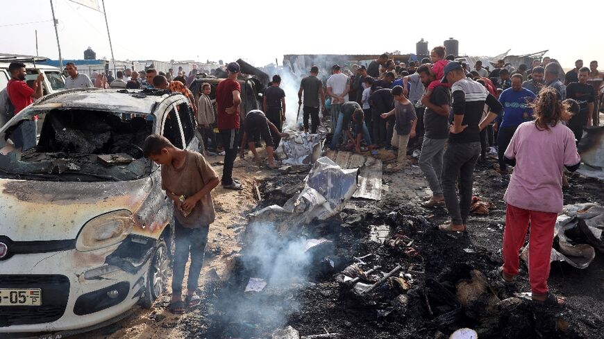 Palestinians gather at the site of the Israeli strike on the camp for displaced people