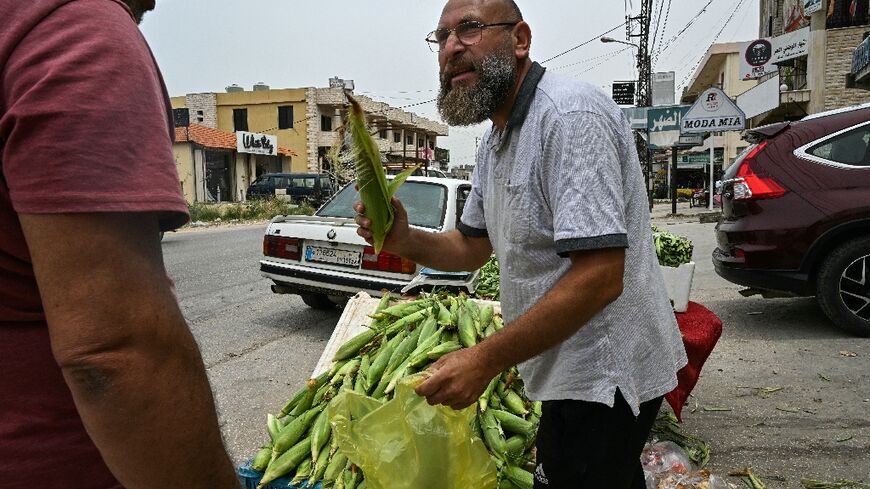 Syrian refugee Hassan Jaber al-Salloum sells vegetables at the roadside in the Lebanese village of Minyara