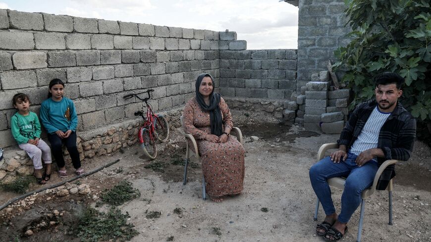 Bassem Eido, a 20-year-old Iraqi man from the Yazidi community, sits with his mother and sisters, in the village of Solagh in the Sinjar region